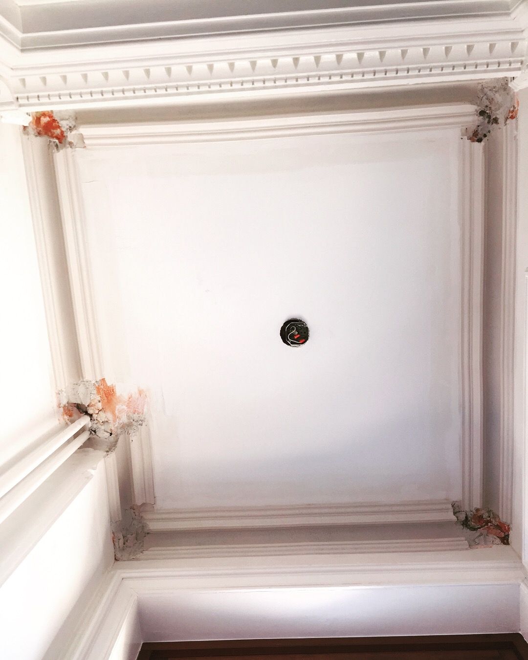 Un plafond blanc avec un trou rond au milieu