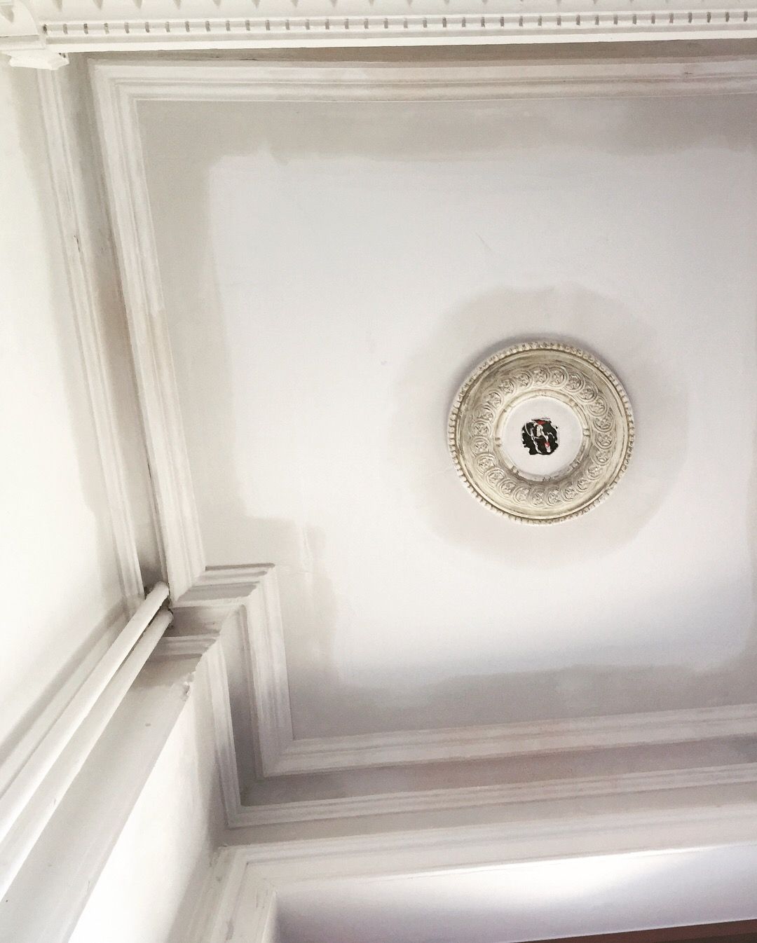 Un plafond blanc avec une lumière circulaire dessus.