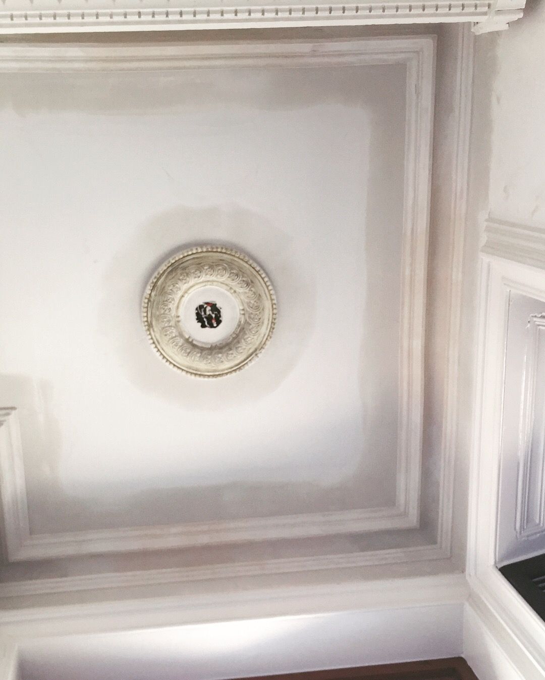 Un plafond blanc avec une décoration ronde dessus.