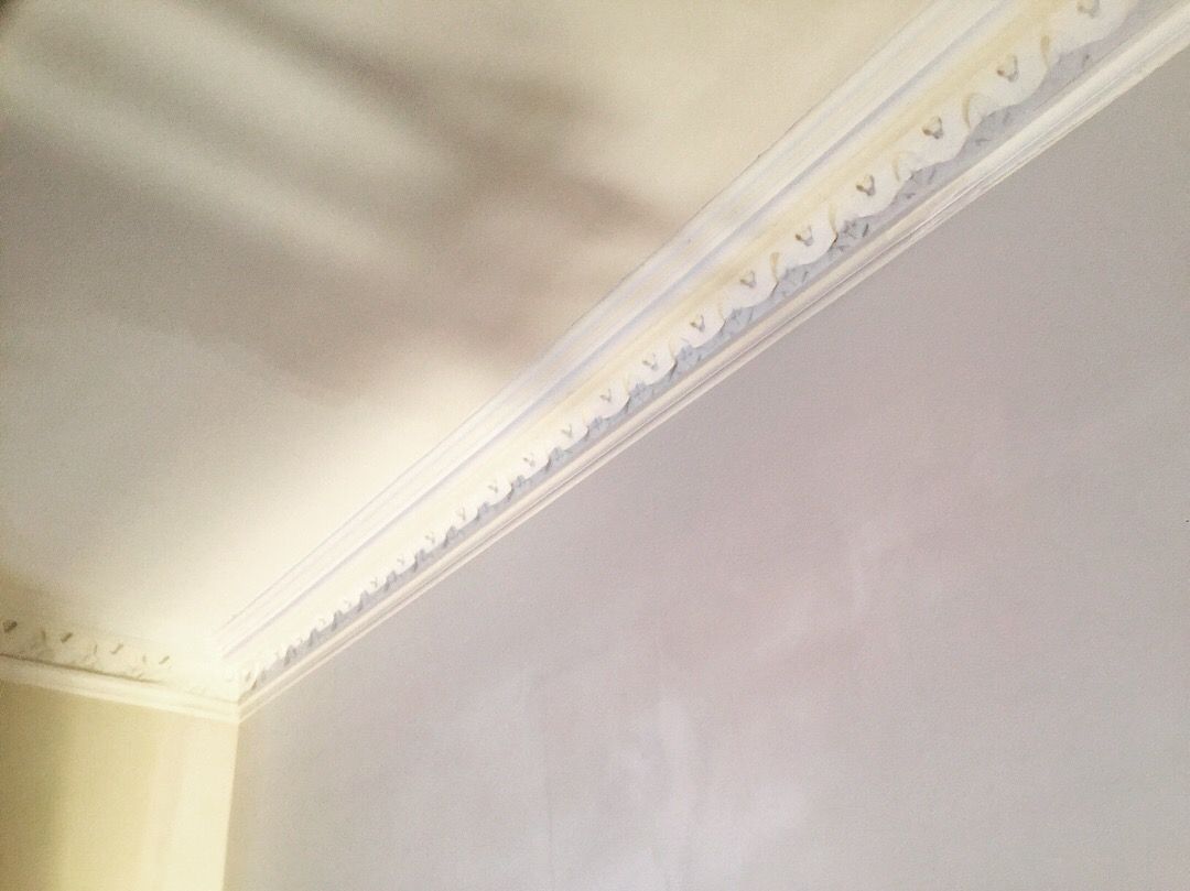 Un gros plan d'une corniche blanche sur un mur blanc.