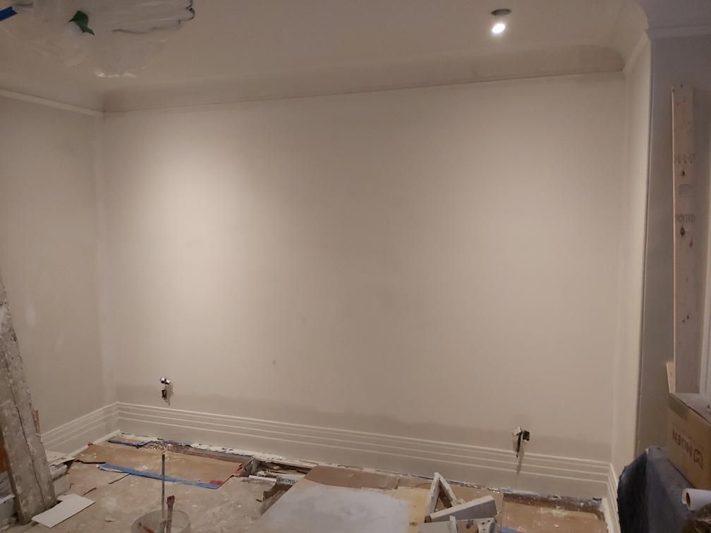 Une pièce avec un mur blanc et un plancher en bois.