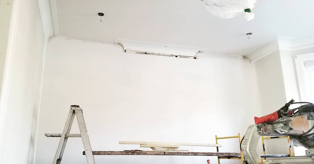 Une pièce avec une échelle et une scie à l'intérieur.