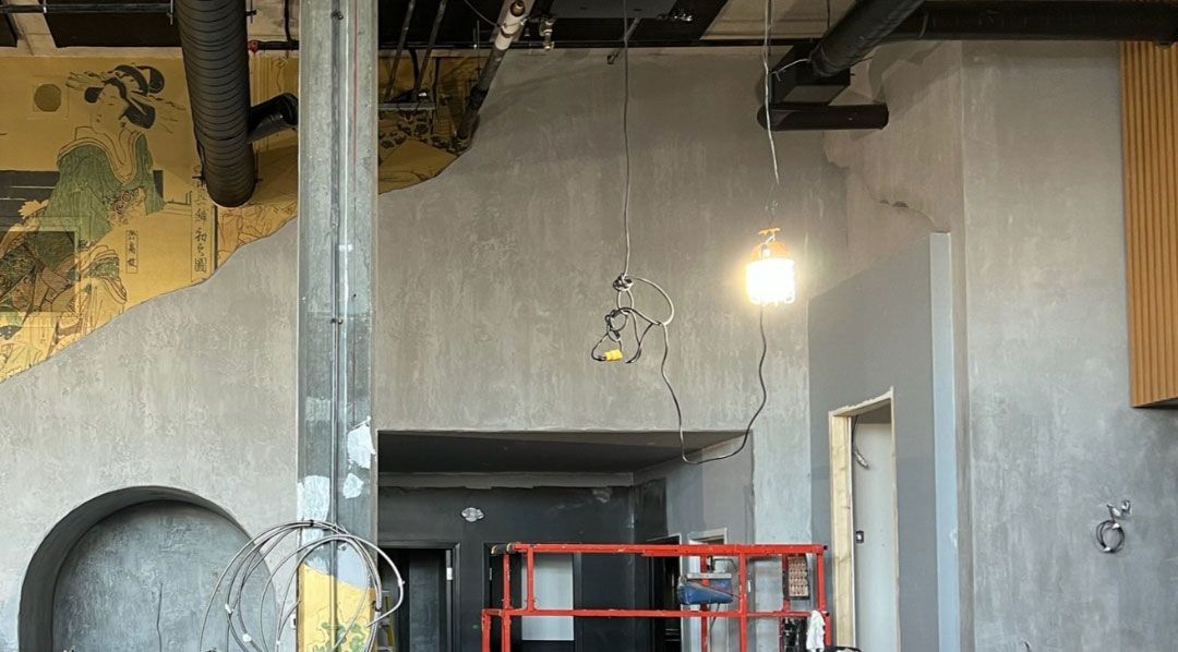 Un chantier avec une échelle et une lumière suspendue au plafond.