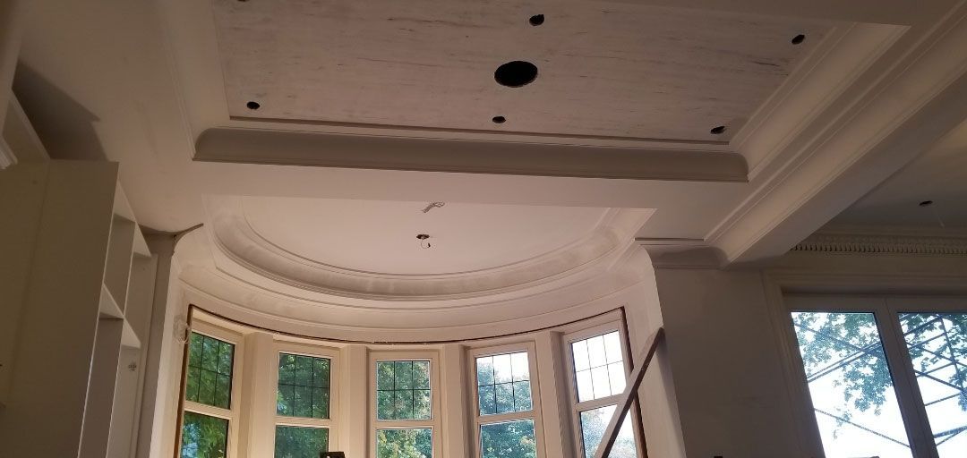 Une pièce avec un plafond incurvé et beaucoup de fenêtres