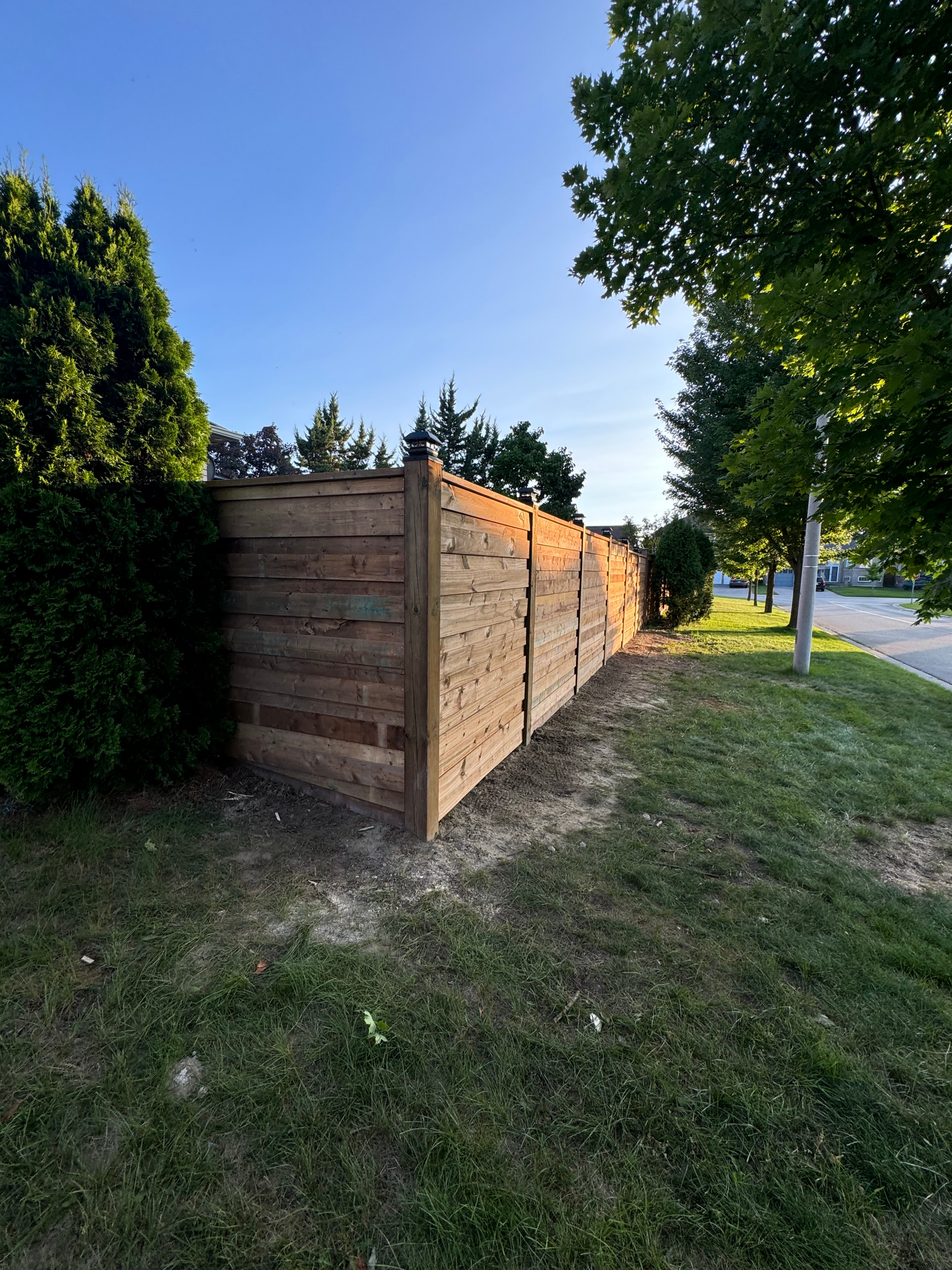 A wooden fence is sitting in the middle of a lush green field.