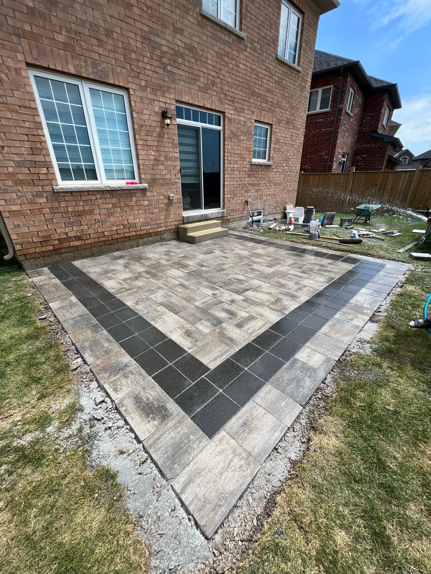 A brick house with a patio in front of it.