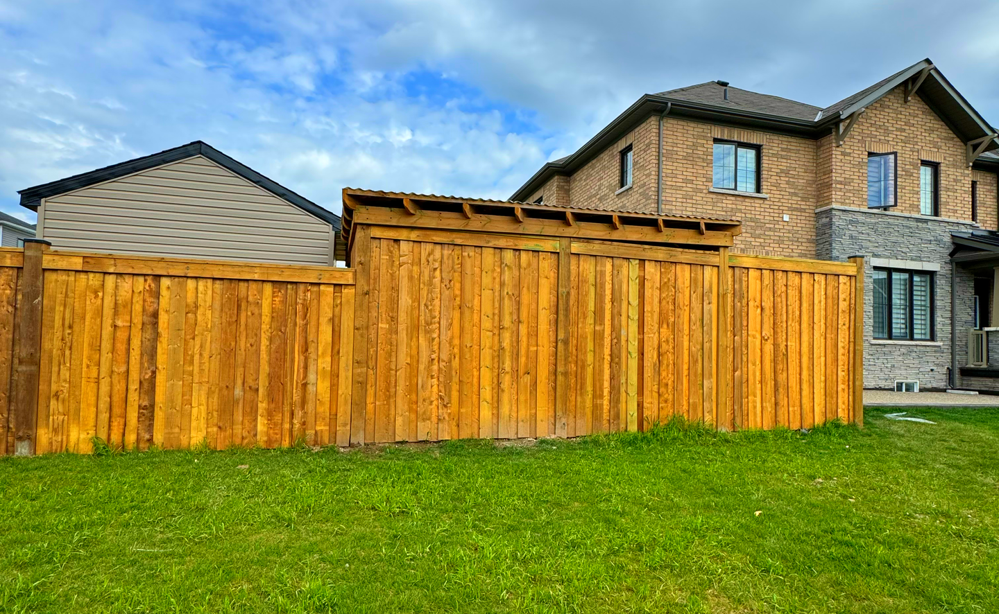 There is a wooden fence in the backyard of a house.
