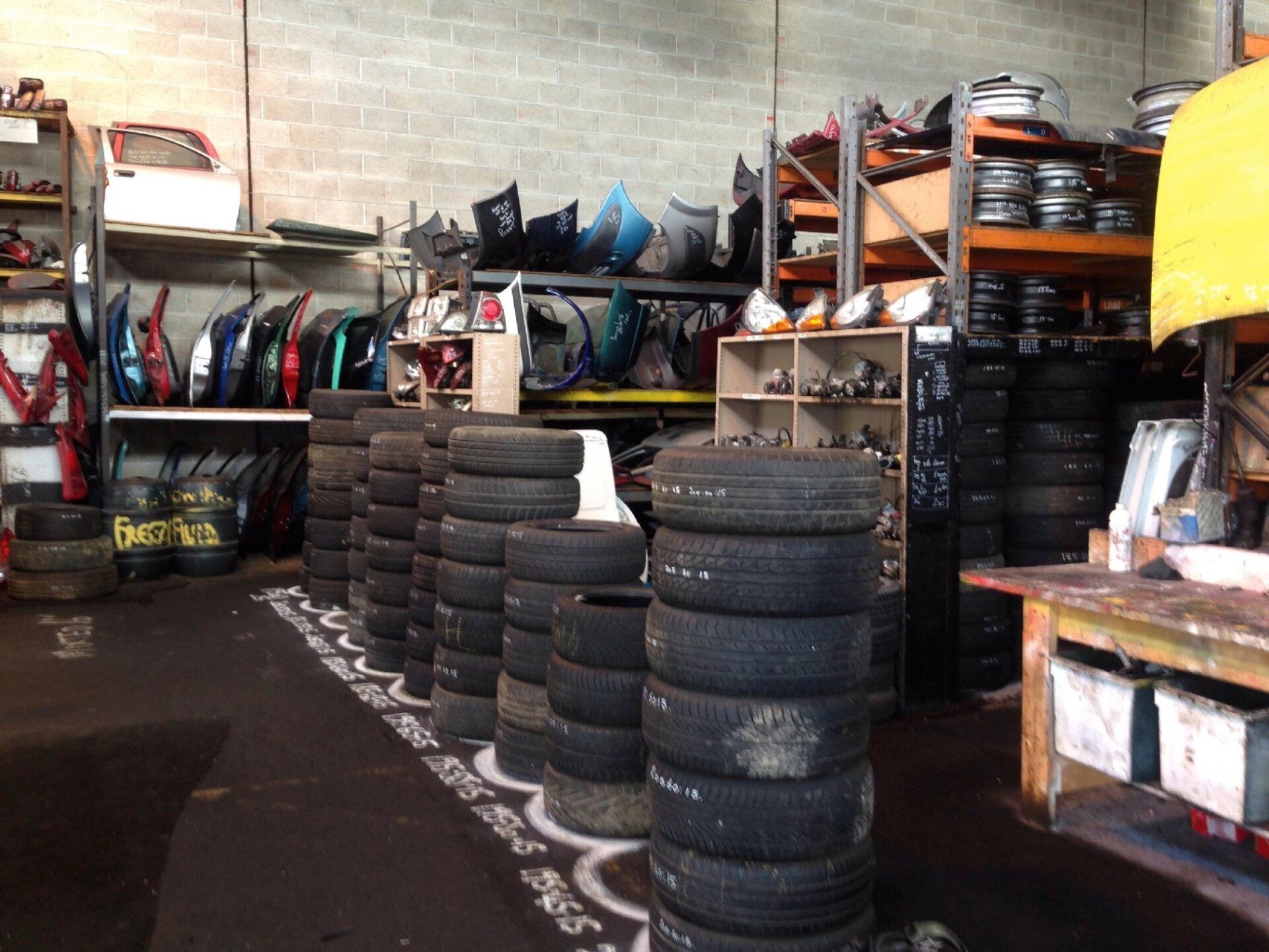 Part worn tyre piles, various old car parts on the shelves