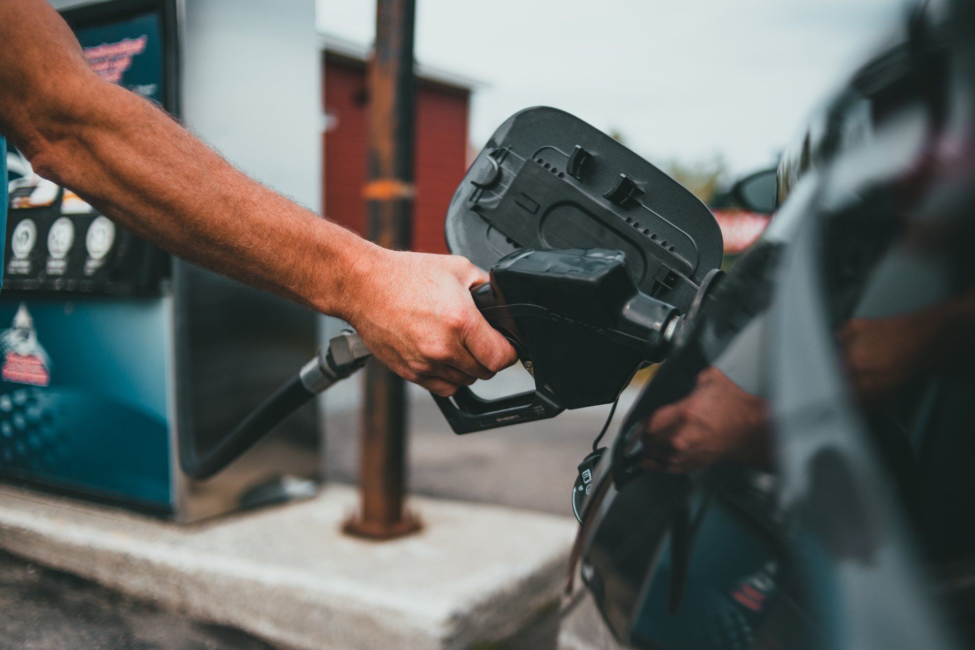 A man is pumping gas into a car at a gas station | Dana Meyer Auto Care