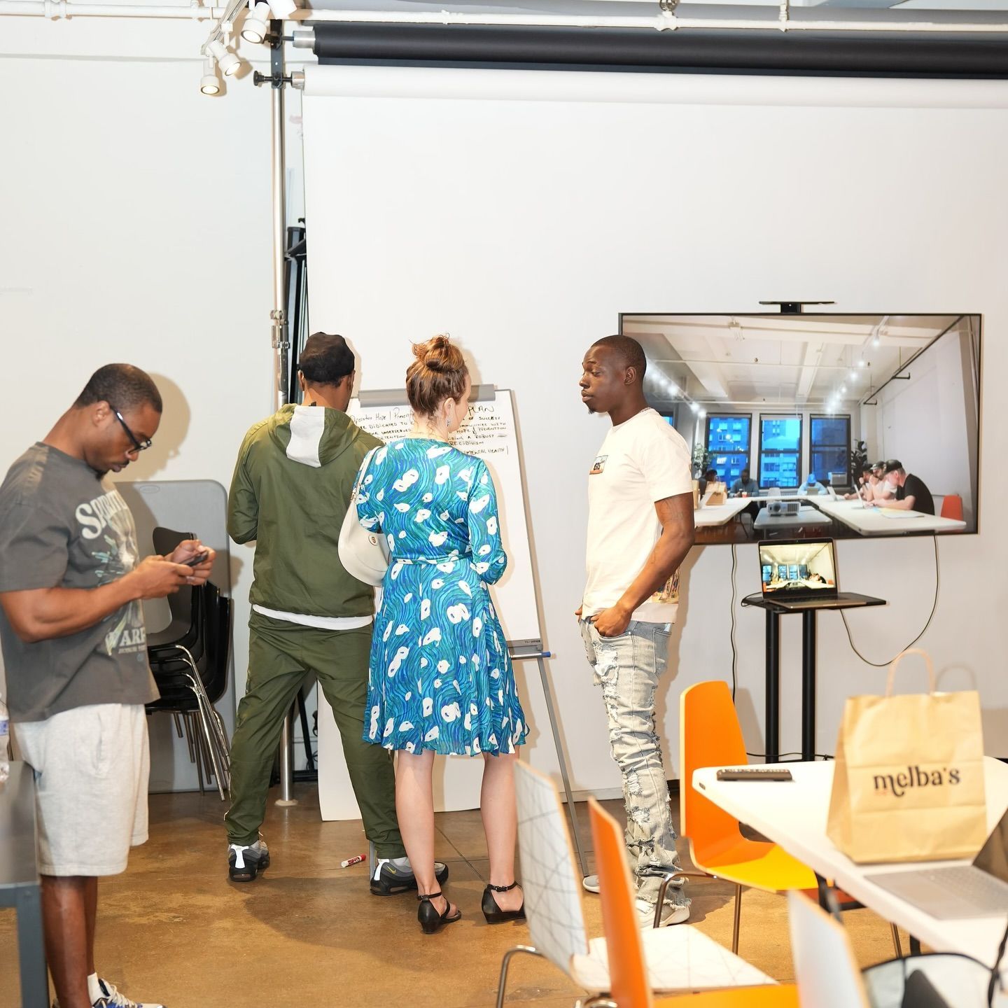 A group of people standing around a table with a bag that says mylife on it