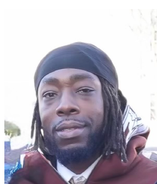 A man with dreadlocks is wearing a headband and a tie.