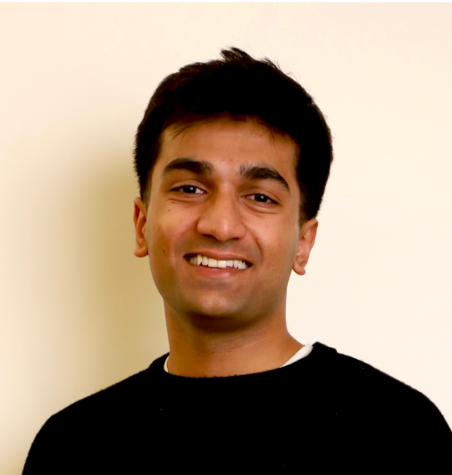 A man wearing a black shirt is smiling for the camera