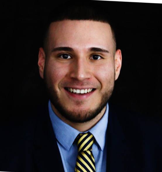 A man in a suit and tie smiles for the camera