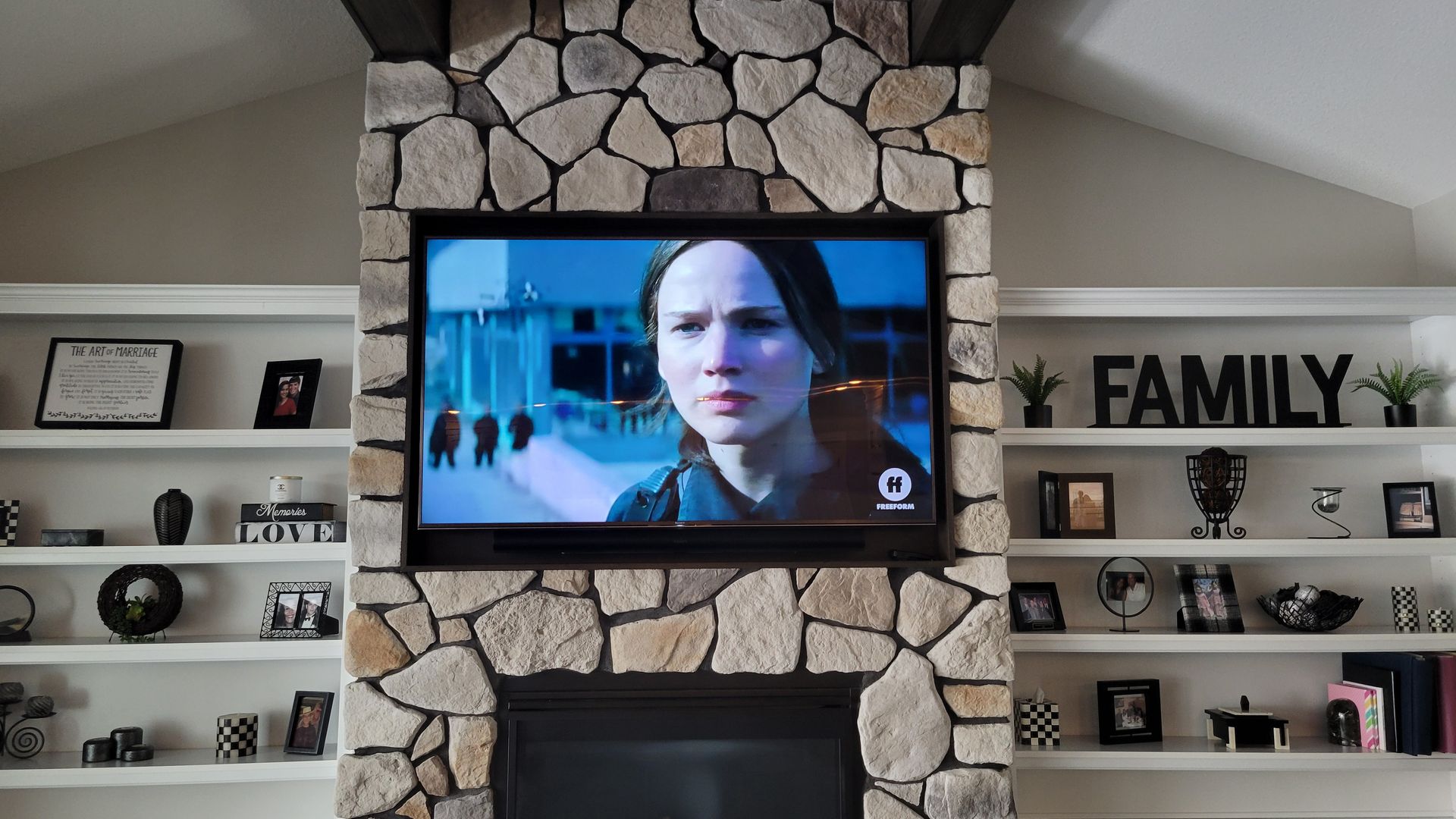 TV and soundbar custom mounted and recessed in a stone fireplace