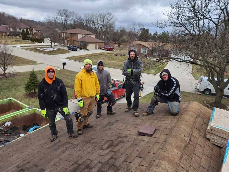 A group of men are standing on top of a roof.
