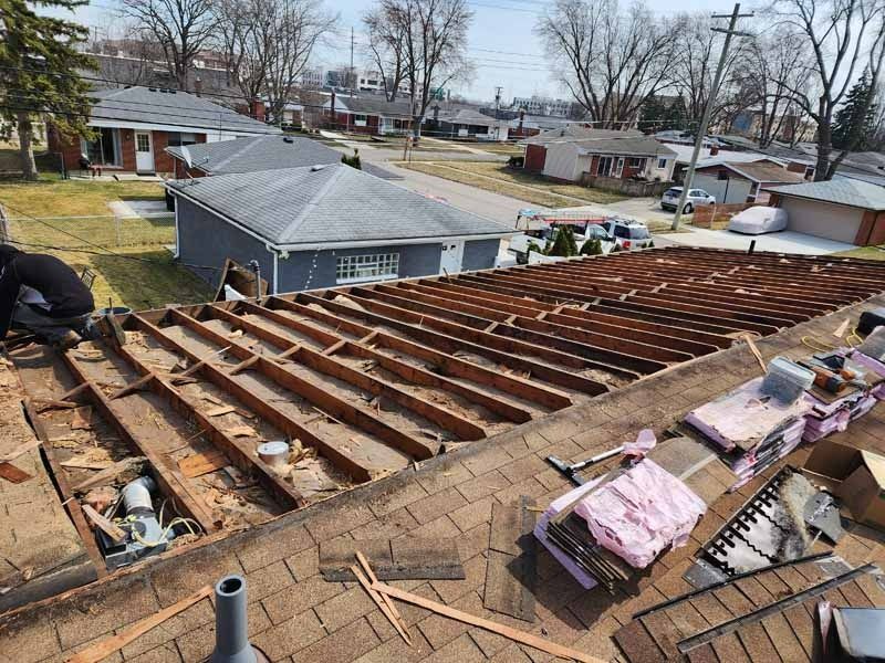 A man is working on the roof of a house.
