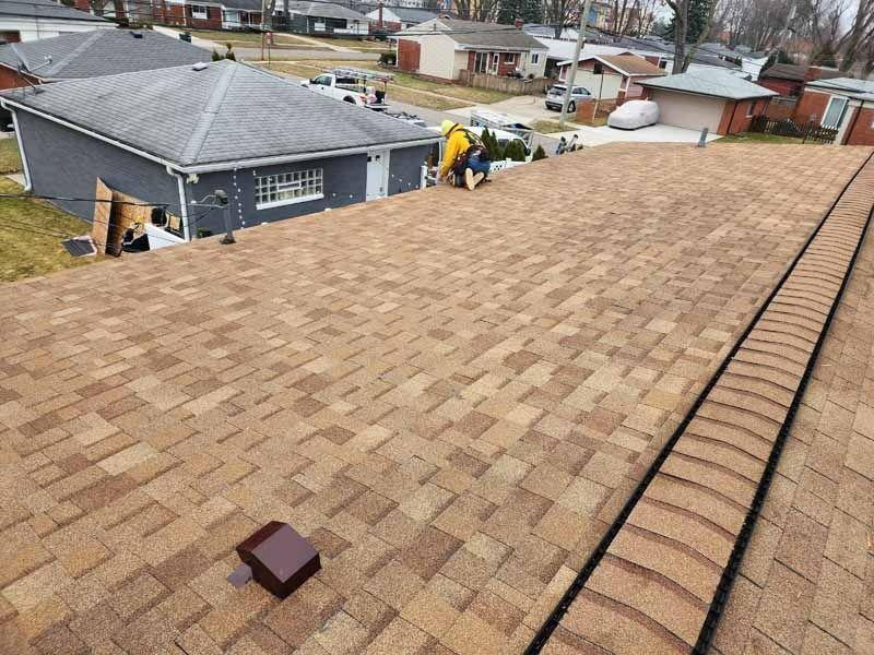 A man is working on the roof of a house.