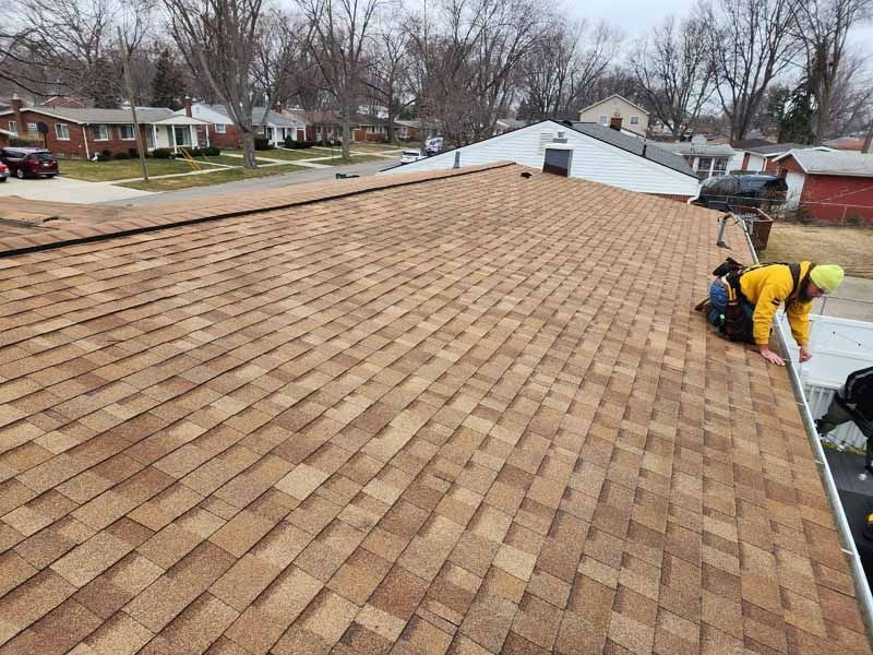 A man is working on the roof of a house.