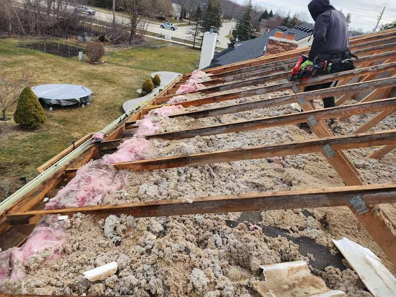 A man is working on the roof of a house.