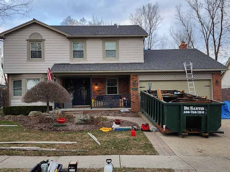 A large house with a dumpster in front of it.