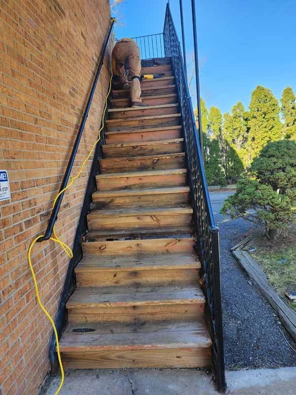 A man is climbing up a set of wooden stairs.