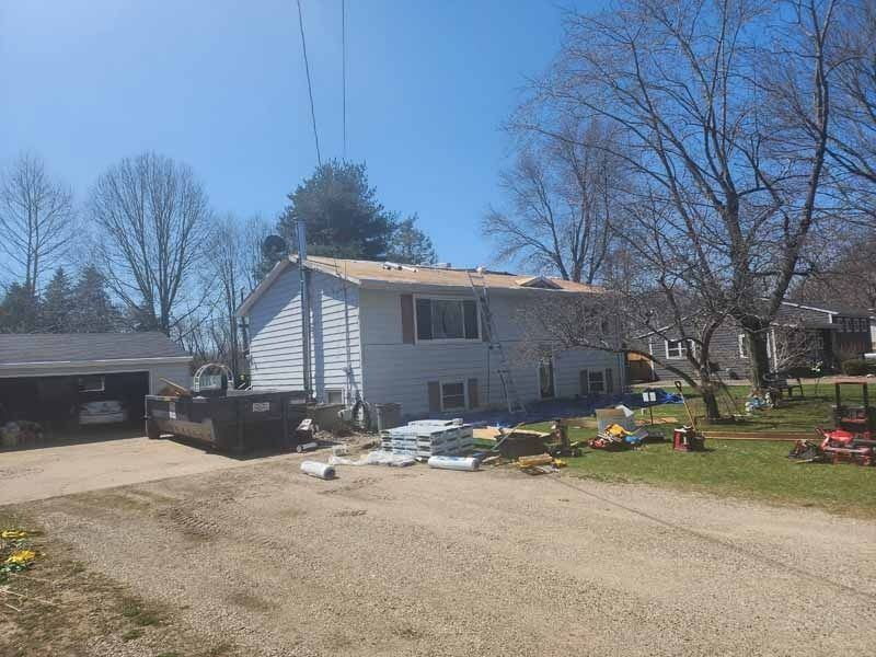 A white house is being remodeled with a new roof.