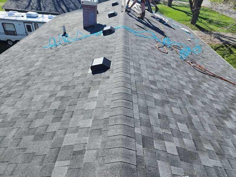 An aerial view of a roof with shingles and a chimney.
