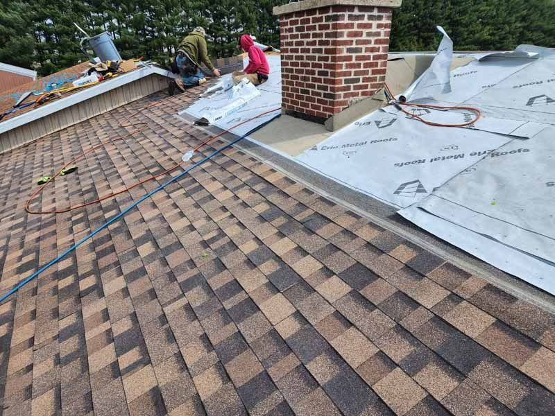 A man is working on the roof of a house.