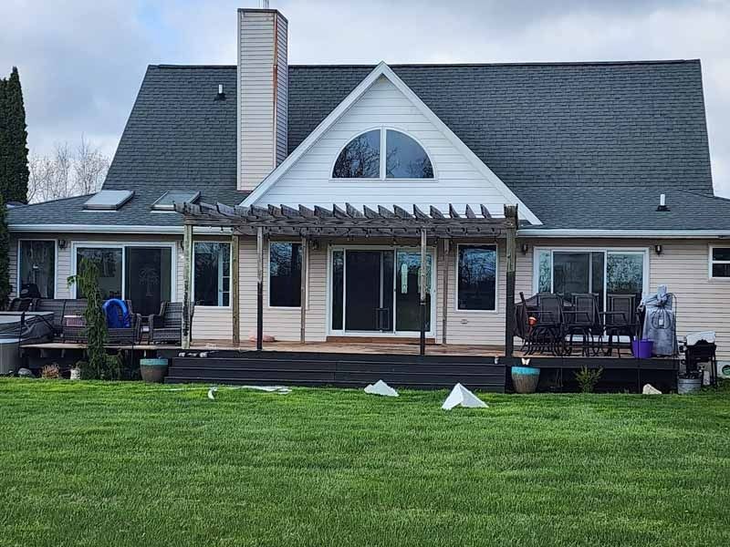 The front door of a house with a black door and a stone wall.