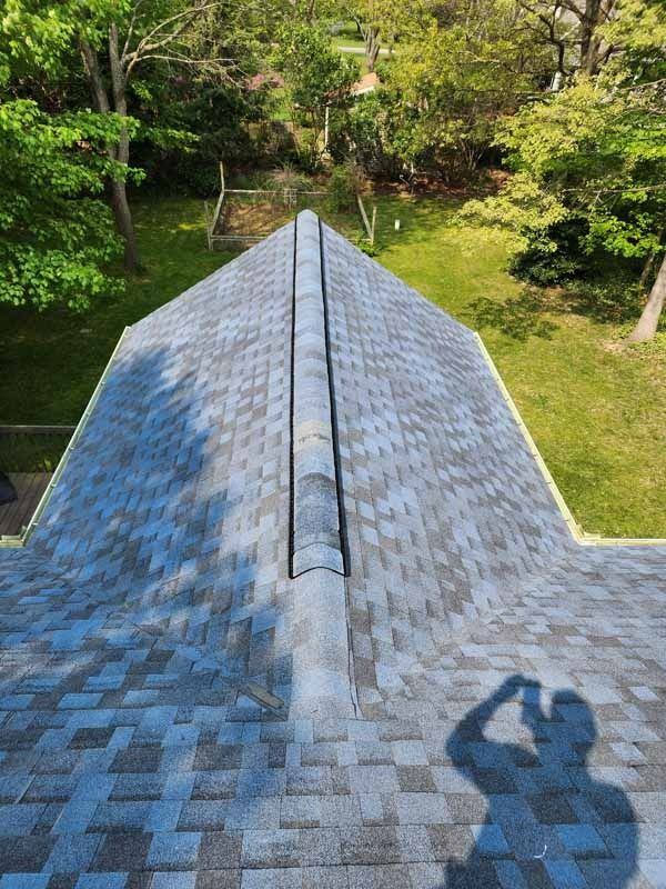 An aerial view of a roof with a shadow of a person on it.