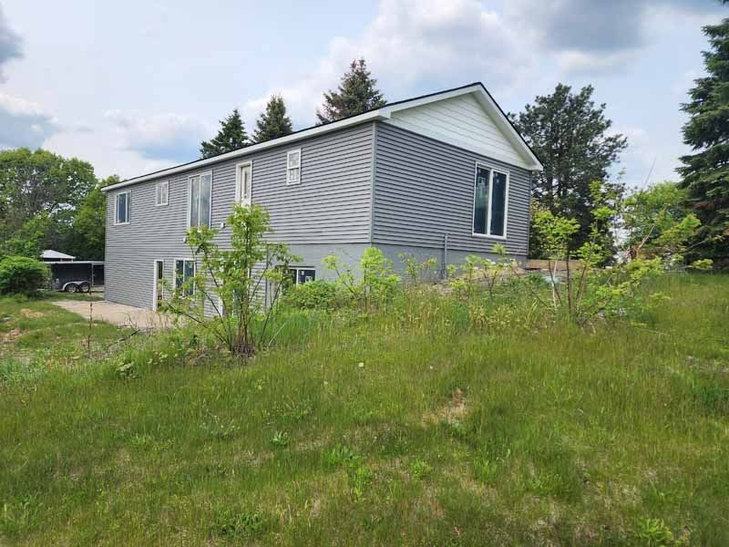 A large house is sitting in the middle of a grassy field.