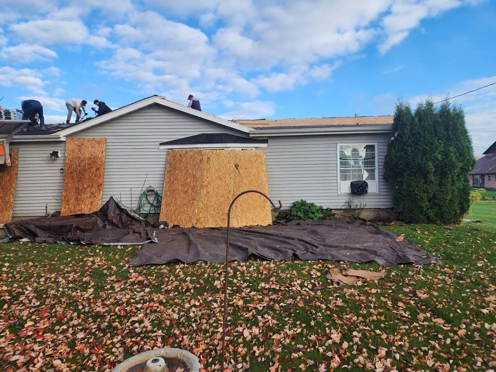 A group of people are working on the roof of a house.
