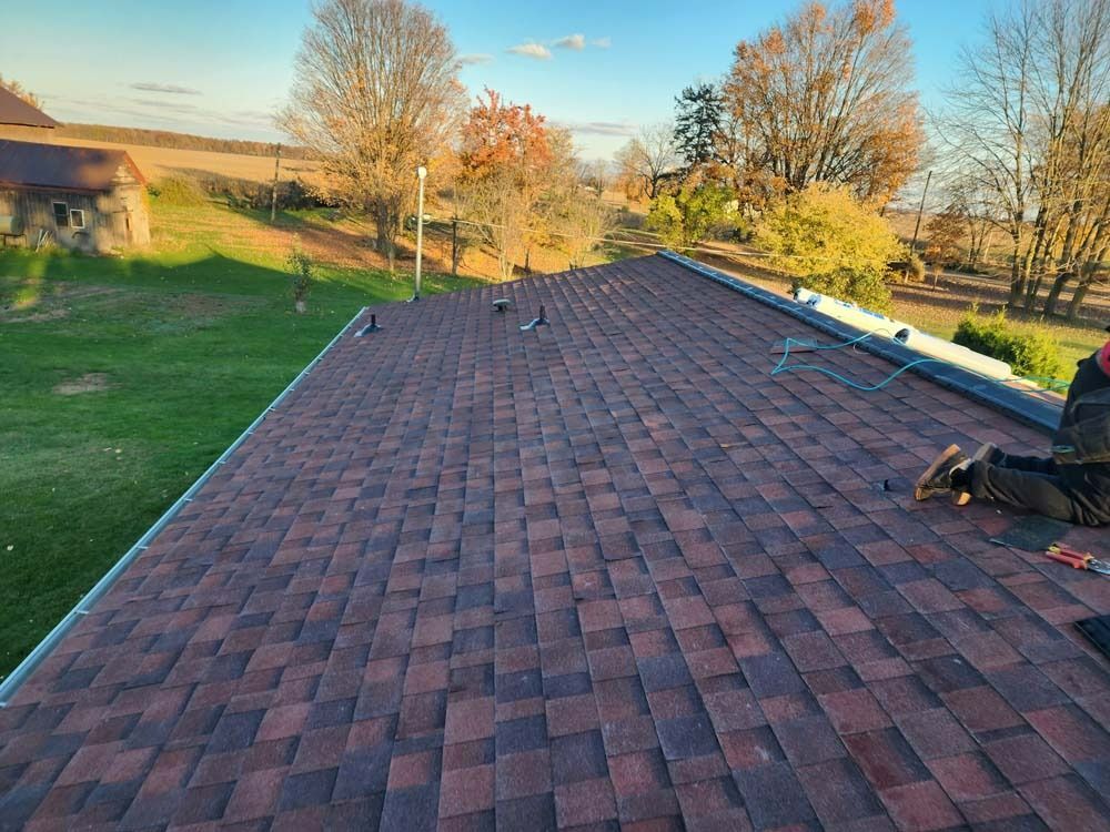 A man is laying on the roof of a house.