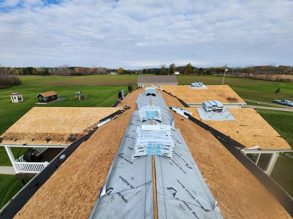 A roof with a lot of shingles on it and a field in the background.