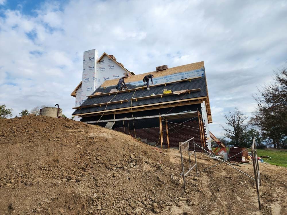 A house is being built on top of a dirt hill.