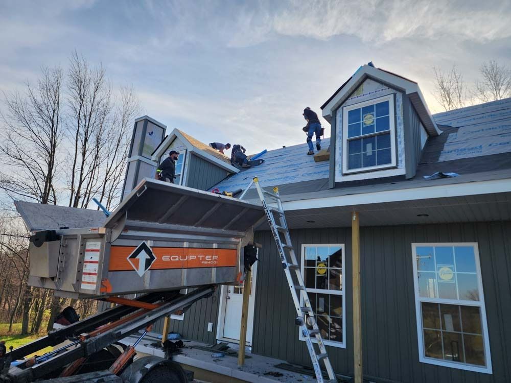 A group of people are working on the roof of a house.