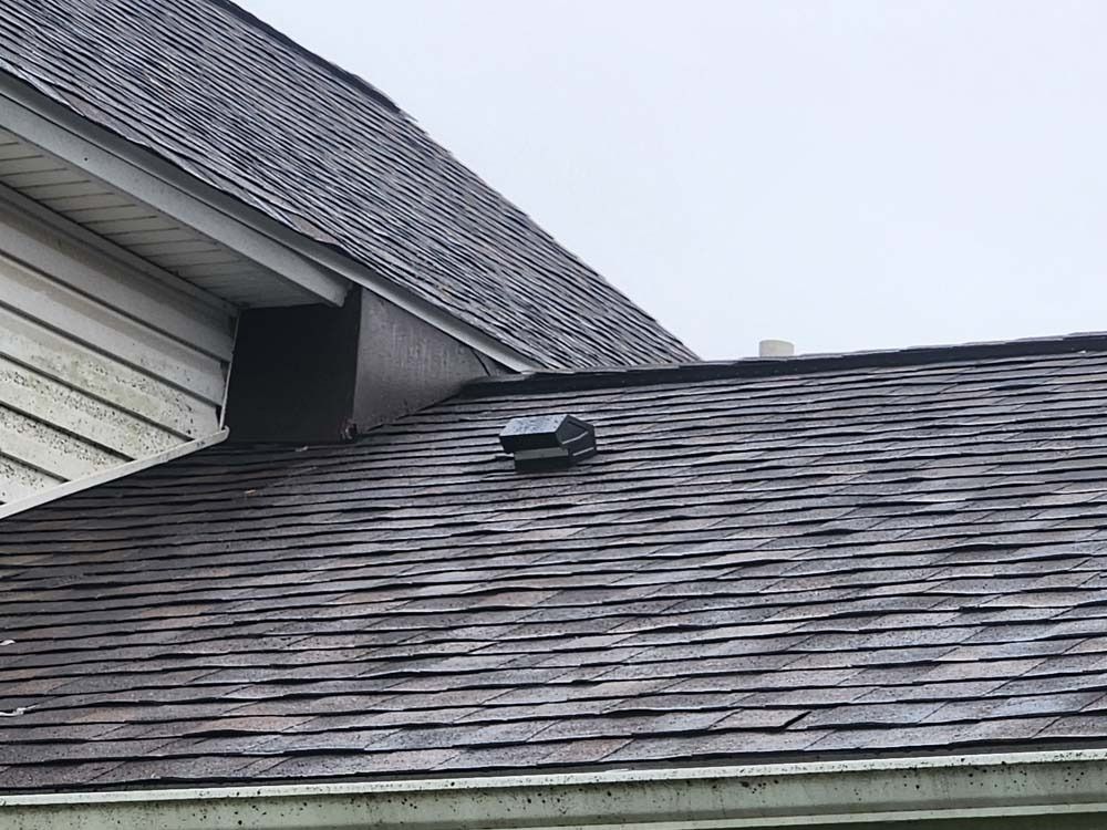 A close up of a roof with a vent on it.