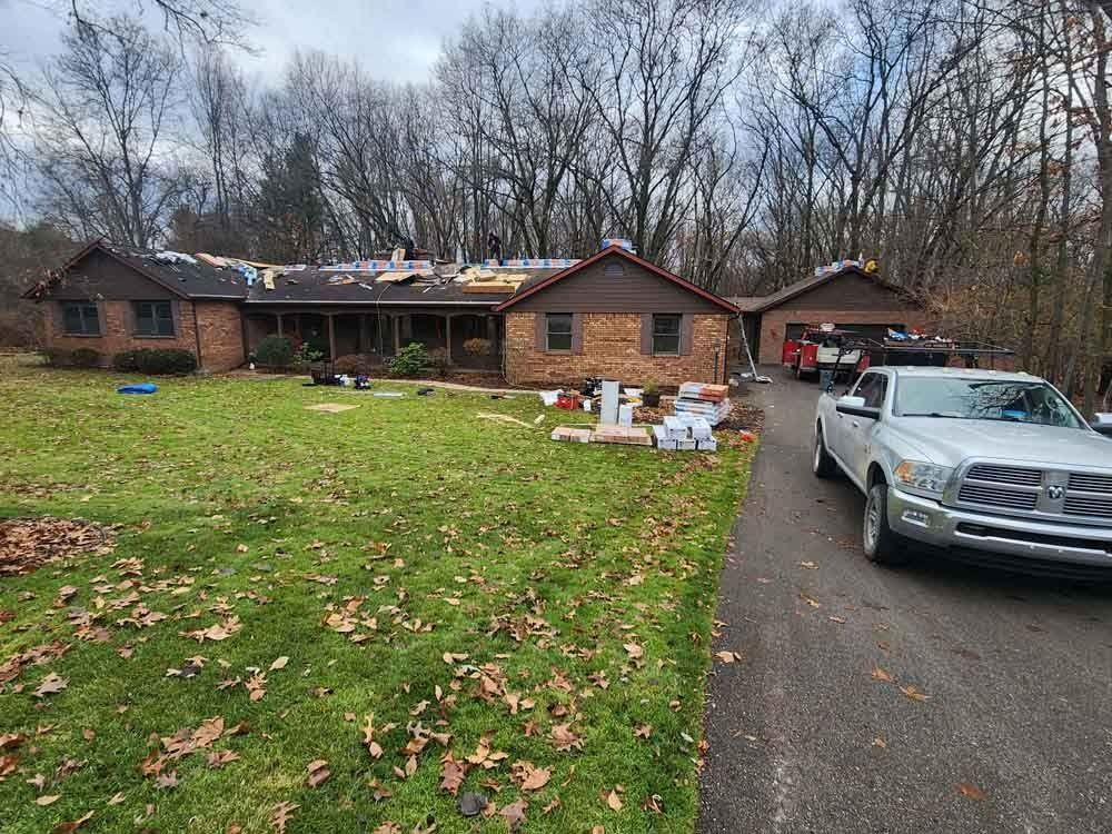 A truck is parked in front of a house that is being remodeled.
