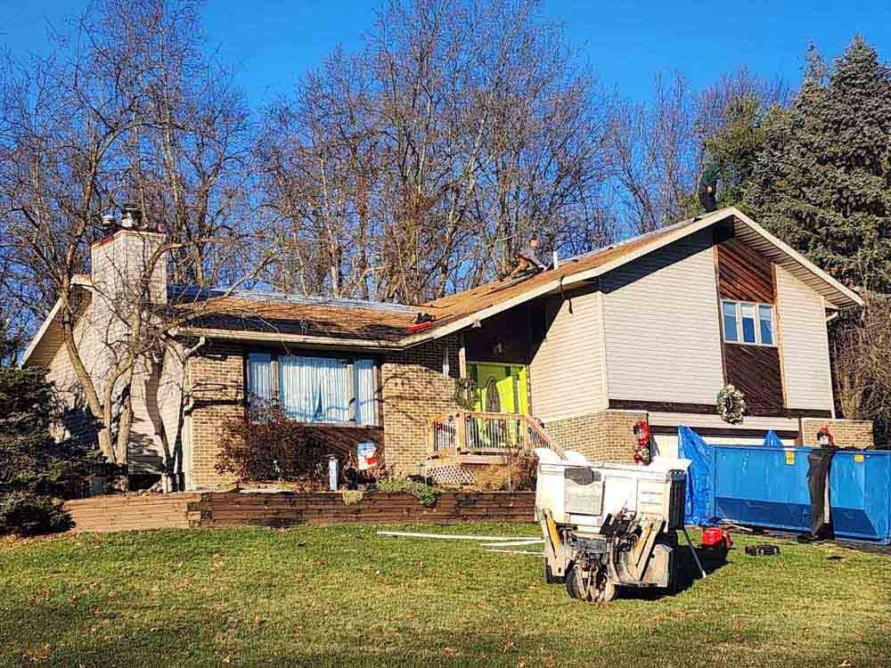 A large house with a dumpster in front of it.