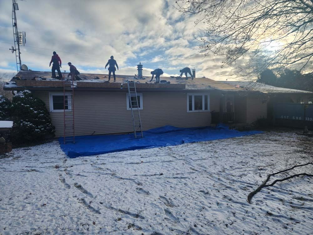A group of people are working on the roof of a house.