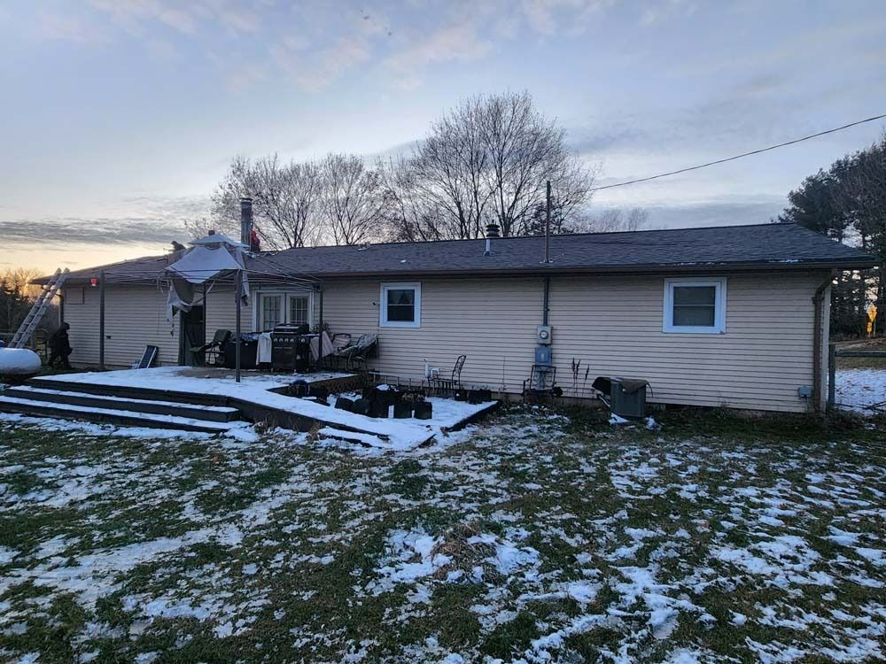 A house is sitting in the middle of a snowy field.