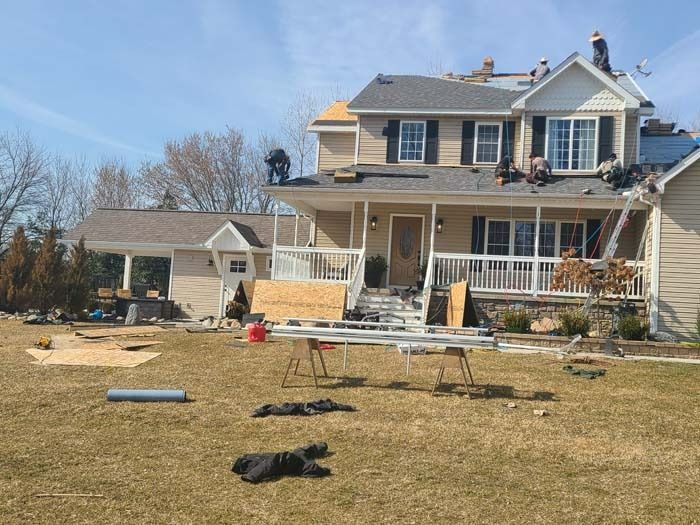 An aerial view of a house with a roof that is being repaired.