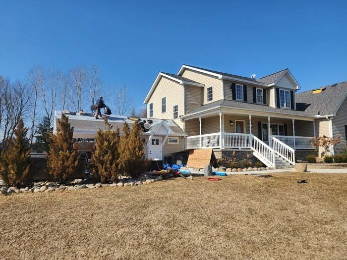 A large house with a trailer parked in front of it and with plain grass