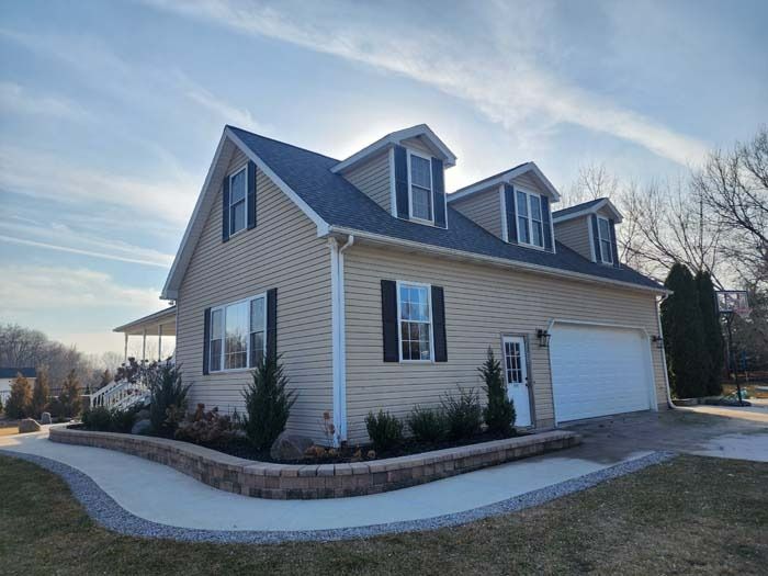 A large house with a garage and a walkway in front of it.