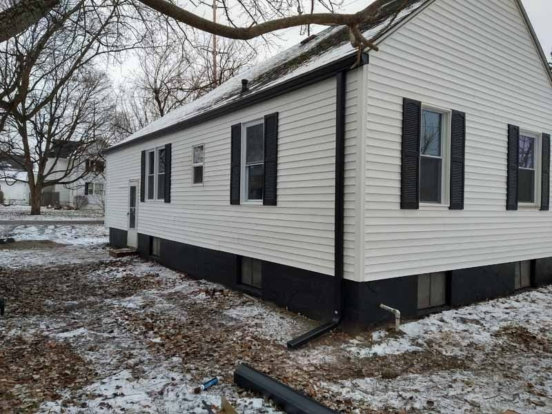 A gutter on the side of a building with a tiled roof.