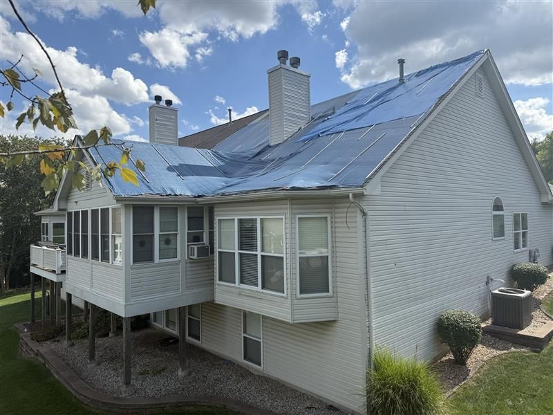 An aerial view of a house with a roof that is being repaired.