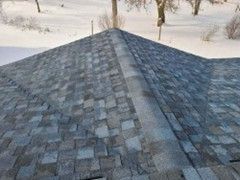 Close-up view of a roof with gray and blue asphalt shingles.