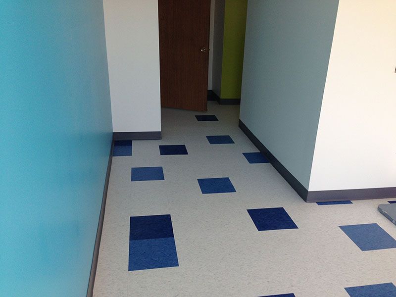 A hallway with blue and white tiles on the floor