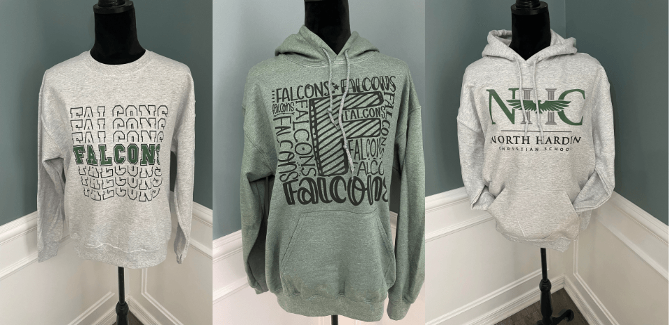 Three sweatshirts on mannequins, with school-related logos in green on gray and green fabrics.