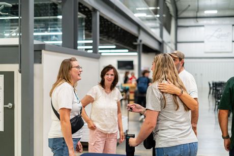 Family walking on a path at night, parents holding the hands of two children, a toddler and a young girl.